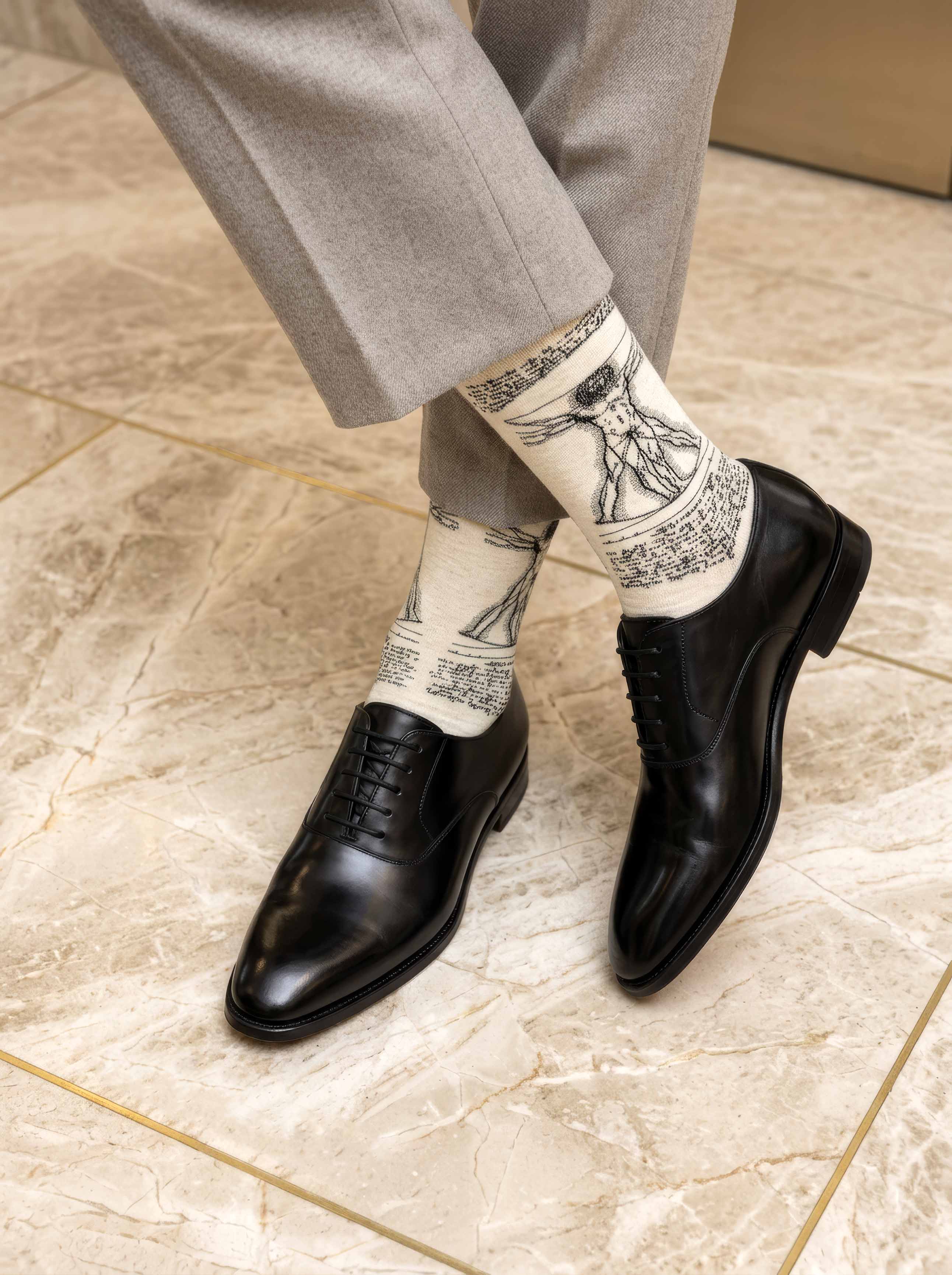 Man wearing Da Vinci Vitruvian Man art socks with black shoes on Da Vinci sketch background — ArtyGifts